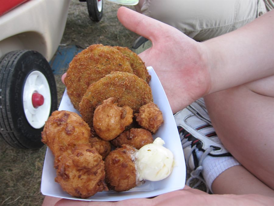 Tray of fried green tomatoes and corn fritters held beside a red toy wagon