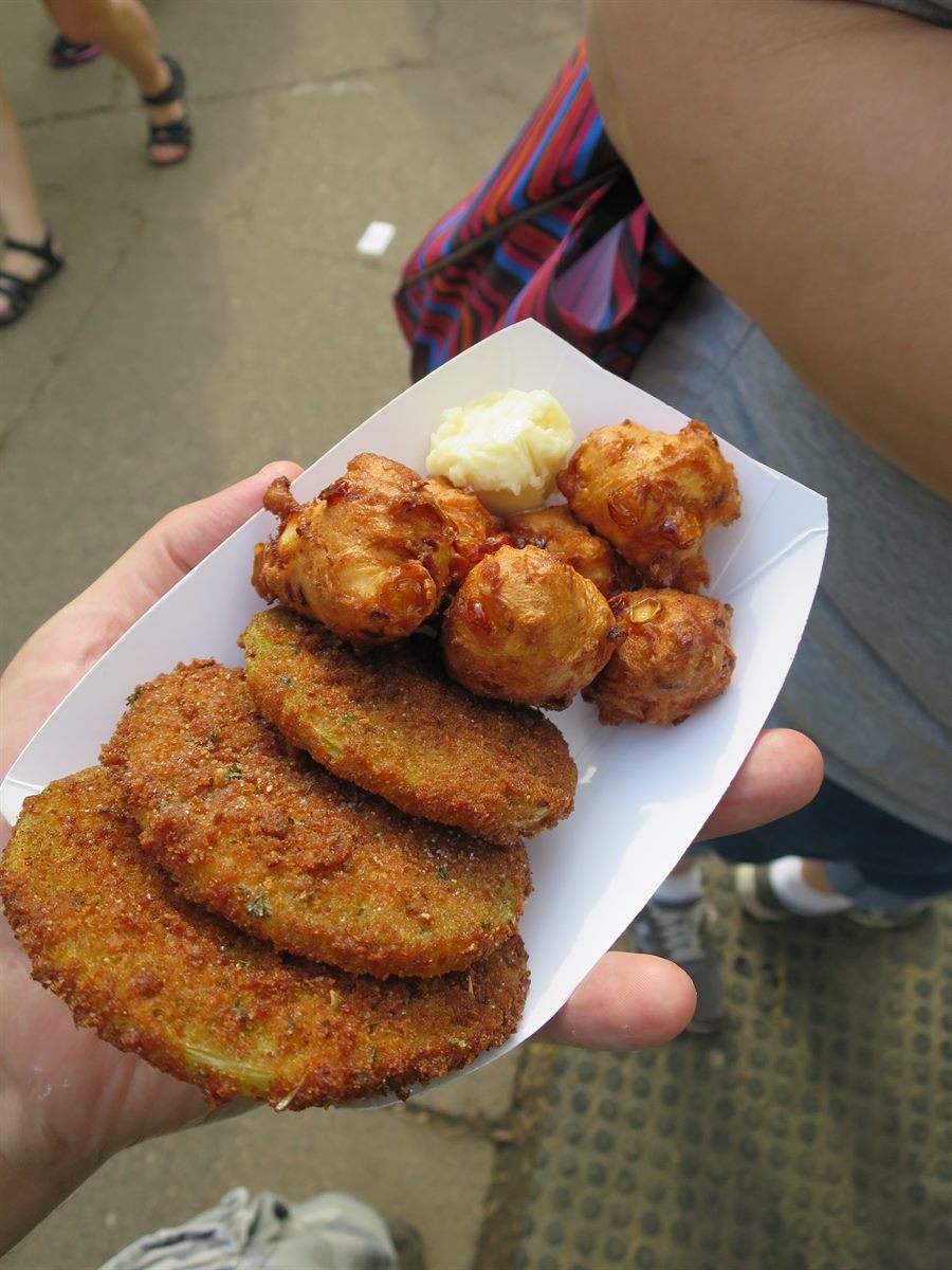 Overhead view of a tray of corn fritters with butter and fried green tomato slices